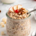 Creamy apple cinnamon overnight oats topped with apples and walnuts