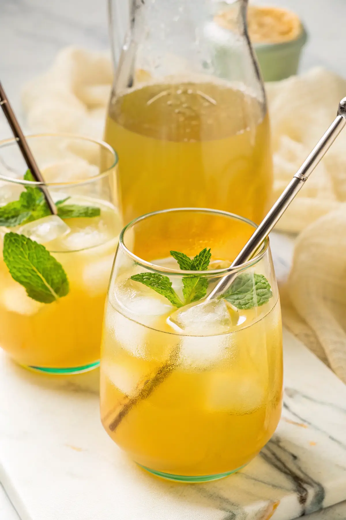 Ingredients for green tea lemonade including lemons, tea bags, honey, and water